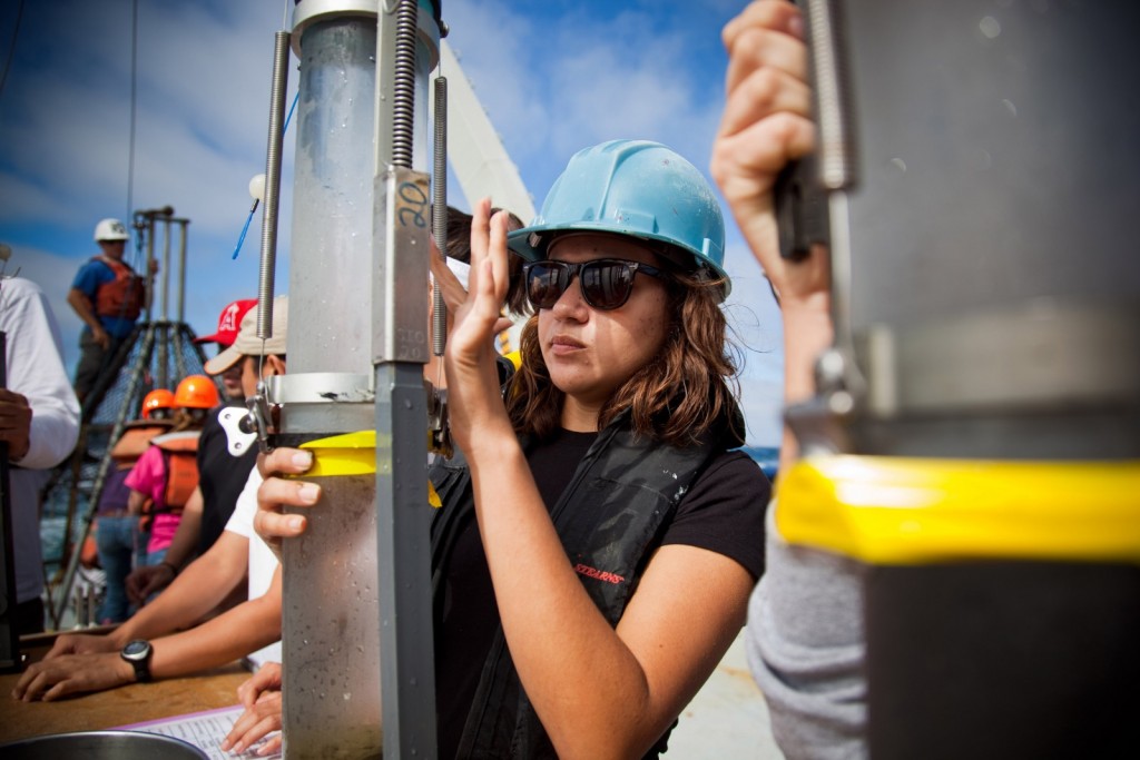 A woman wearing a hard hat participates in a science experiment.