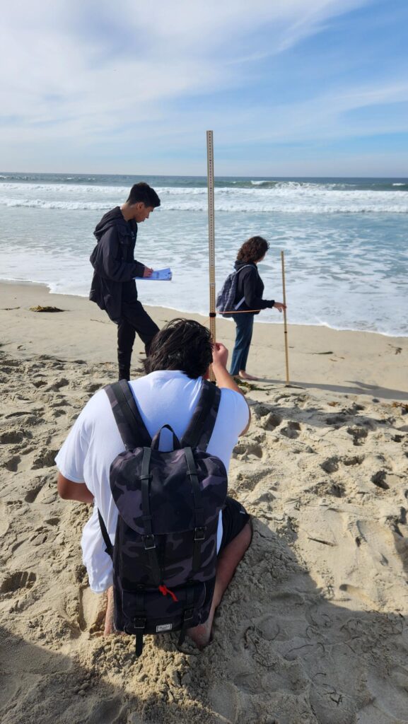 Three people conducting research at the beach